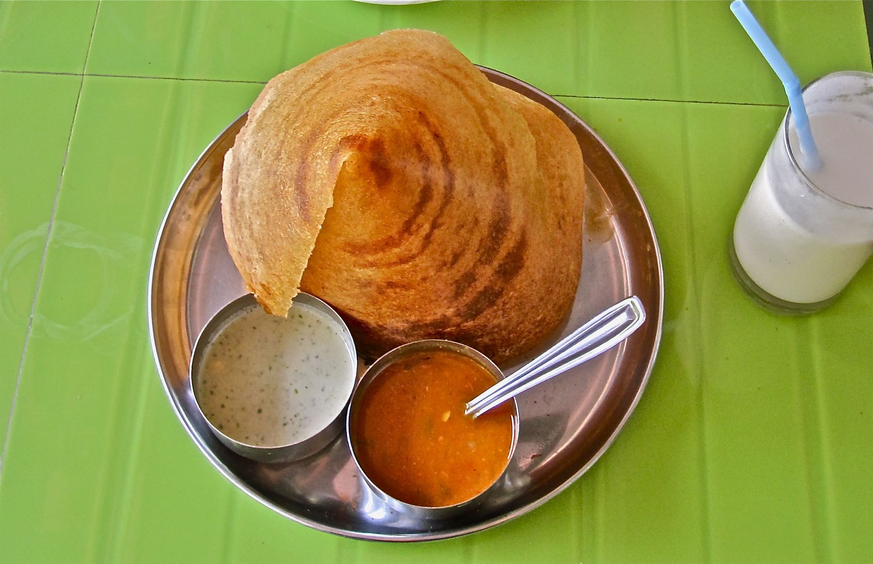 Placeholder photo: a crisp masala dosa served on a banana leaf with sambar and chutneys in small steel bowls — to be replaced with Garuda's own photography