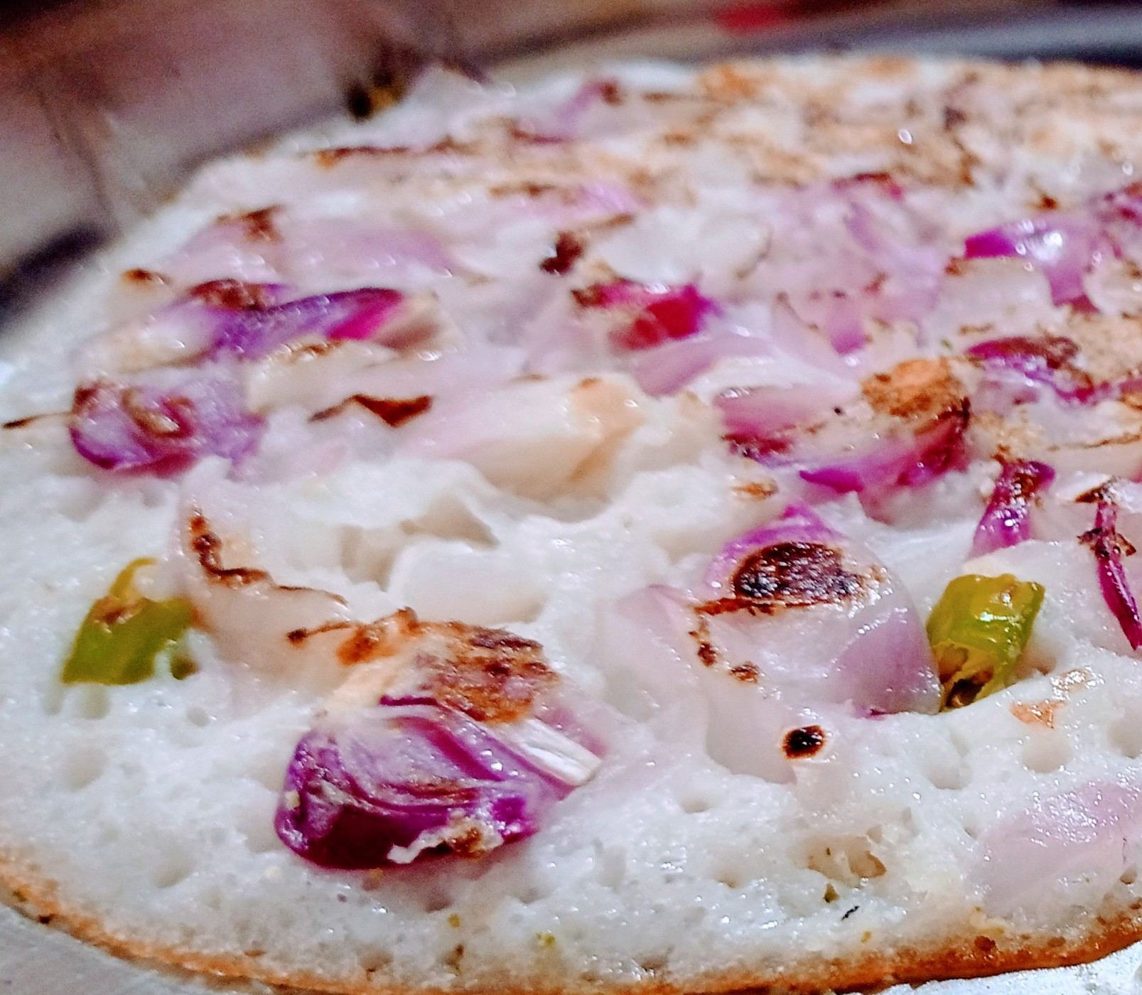 Placeholder: close-up of onion uttapam on a griddle